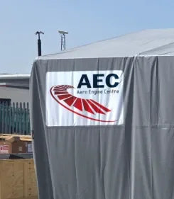 Printed vinyl tent sticker with AEC Aero Engine Centre logo on grey outdoor structure, UK made